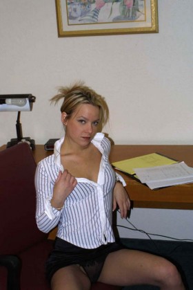 Blonde sexy en train de se devêtir au bureau